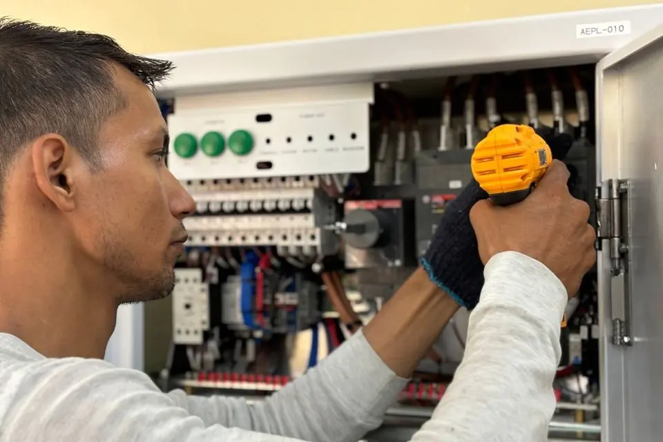 A man is working on an electrical panel