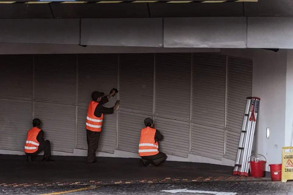 Workers Installing Security Shutters at Entrance