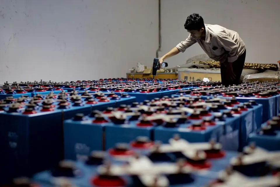 Industrial Worker Inspecting Batteries in Warehouse