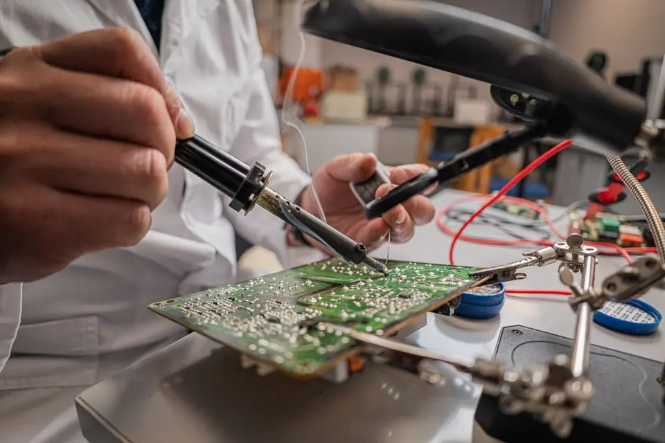 Technician Soldering a Circuit Board in Lab
