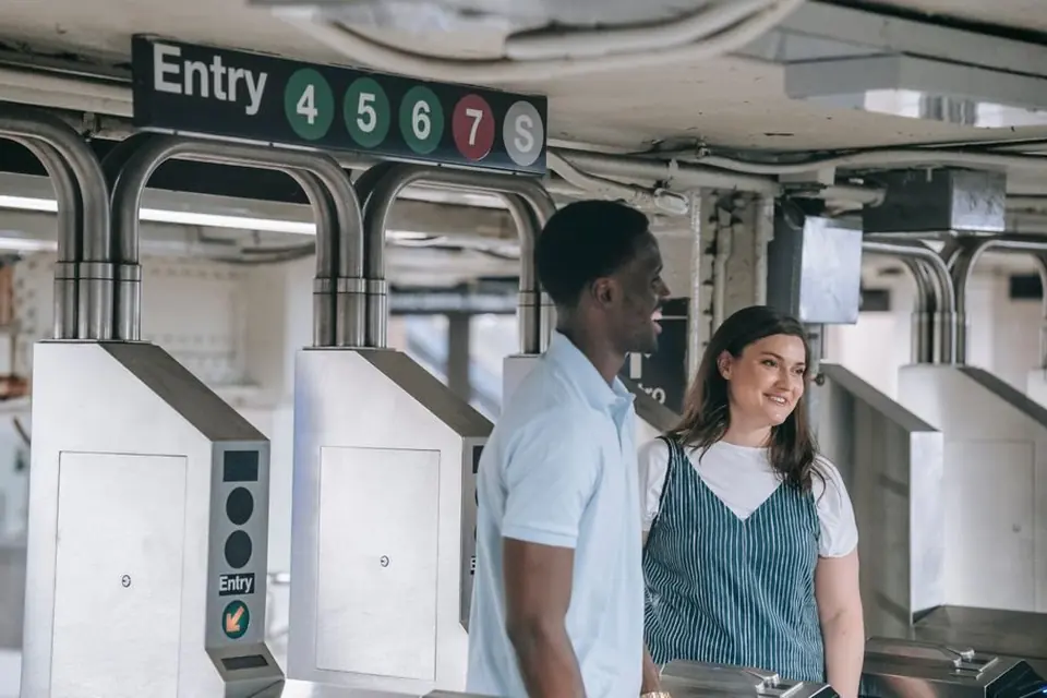 Man and Woman Standing on Train Station Entrance